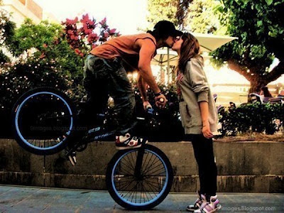 Фото-идея: Лучшие спортивные поцелуи. Парень на велике на переднем колесе целует девушку