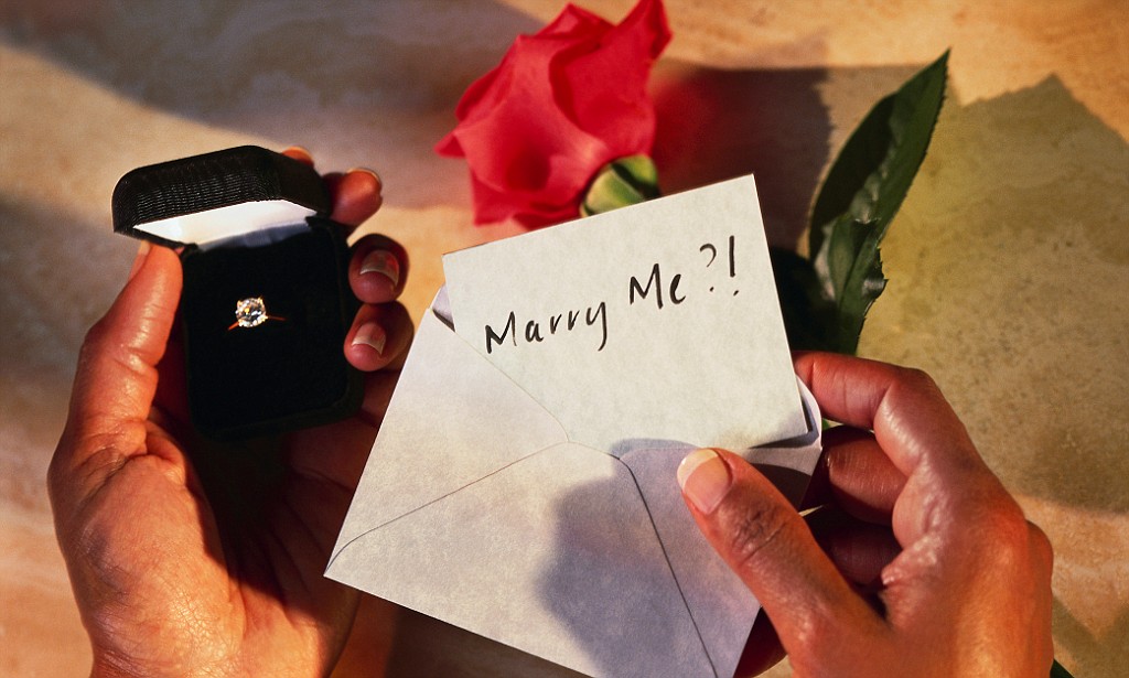 Hands Holding Box with Engagement Ring and Marry Me? Card --- Image by © Barry Gregg/Corbis