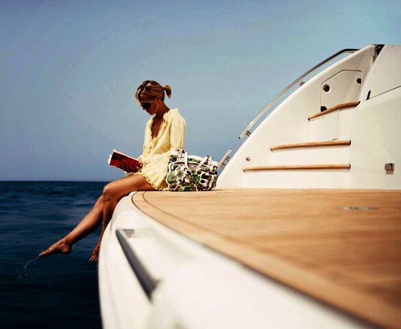 Молодая девушка читает книгу на яхте