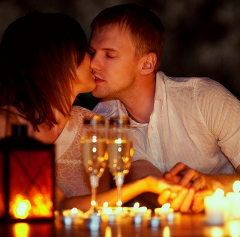 Девушка и парень целуются при свечах