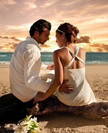 Мужчина с женщиной сидят на пляже на закате