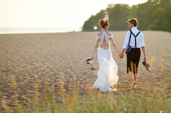 Невеста и жених на пляже на закате — стоковое фото