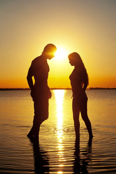 Пара силуэт на пляж на закате — стоковое фото