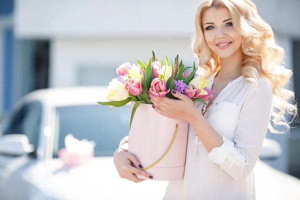 Beautiful blonde with flowers in gift box — стоковое фото
