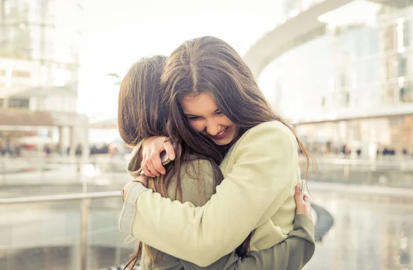 Две девушки, обнимая друг друга после долгого времени они были дис — стоковое фото