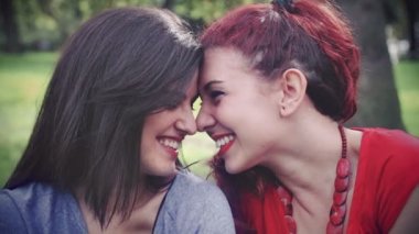 Две молодые привлекательные подруги, поцелуи в парке — стоковое видео