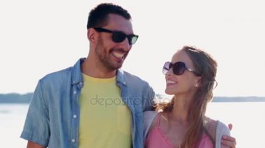 Счастливая пара в солнцезащитные очки, обнимая над морем — стоковое видео