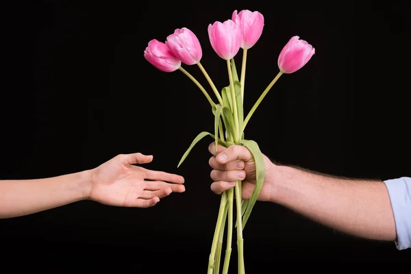 Человек, представляющий тюльпаны женщине — стоковое фото