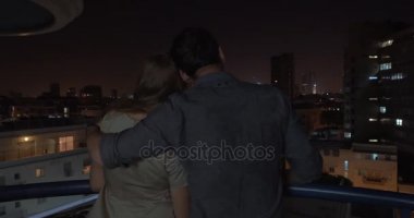 Глядя на ночной город, находясь в объятия любящий человек — стоковое видео