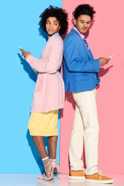 Молодые Африканские Amercian Улыбаясь Пара Телефонами Стоя Спиной Спине Розовый — стоковое фото