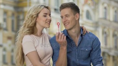 Привлекательная блондинка женщина выдувания мыльных пузырей и целуя ее бойфренд, Дата — стоковое видео