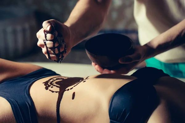 Женский сексуальный живот и мужской руки шоколадный массаж — стоковое фото