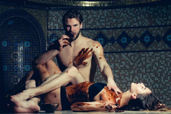 Мускулистый мужчина и сексуальные женщины едят шоколад после салон Массаж — стоковое фото