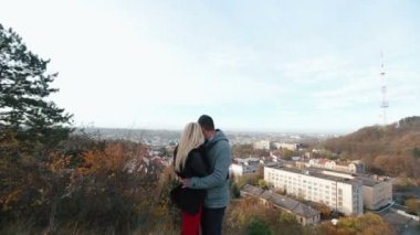 Человек обнимает нежная женщина в шубке, глядя на город от Хилл — стоковое видео