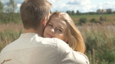 Портрет блондинка, который обнимать ее бойфренд и счастливо улыбаясь — стоковое видео