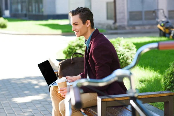 Вид Сбоку Улыбающийся Молодой Человек Используя Ноутбук Пустой Экран Скамейке — стоковое фото