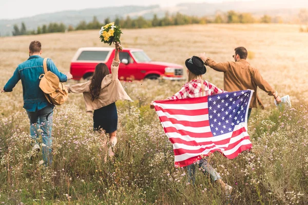 Rear View Group Young American Travellers Flag Walking Flower Field — стоковое фото