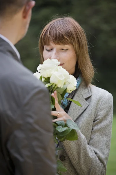 Женщина запахи на цветы — стоковое фото