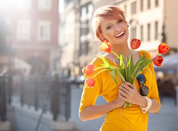 Улыбается женщина с букетом цветов — стоковое фото